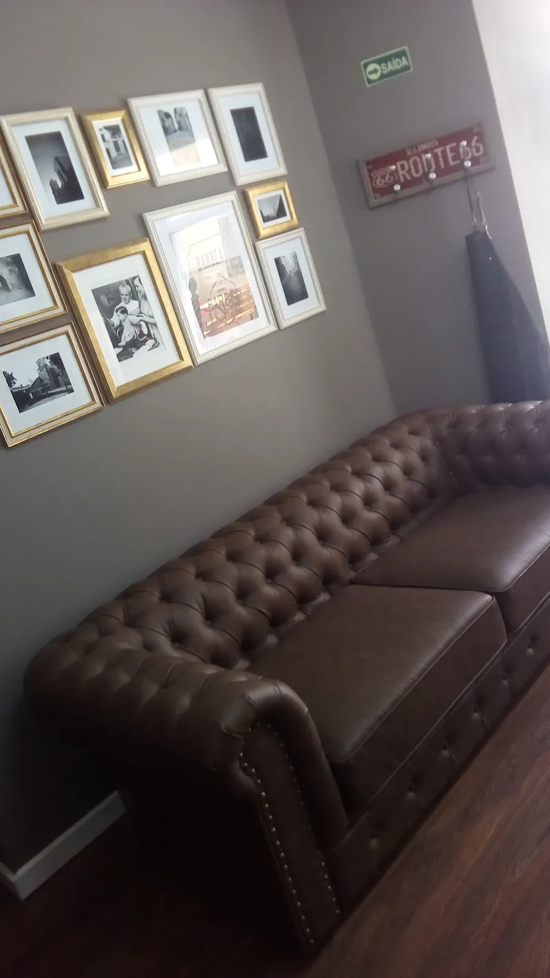 Sofá chesterfield e parede de fotografias